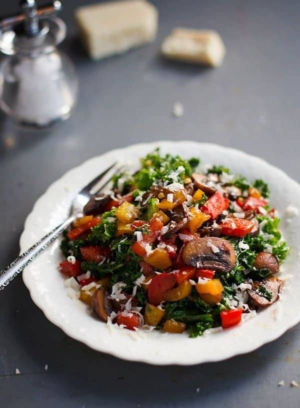 Balsamic kale salad on a white plate with a fork.