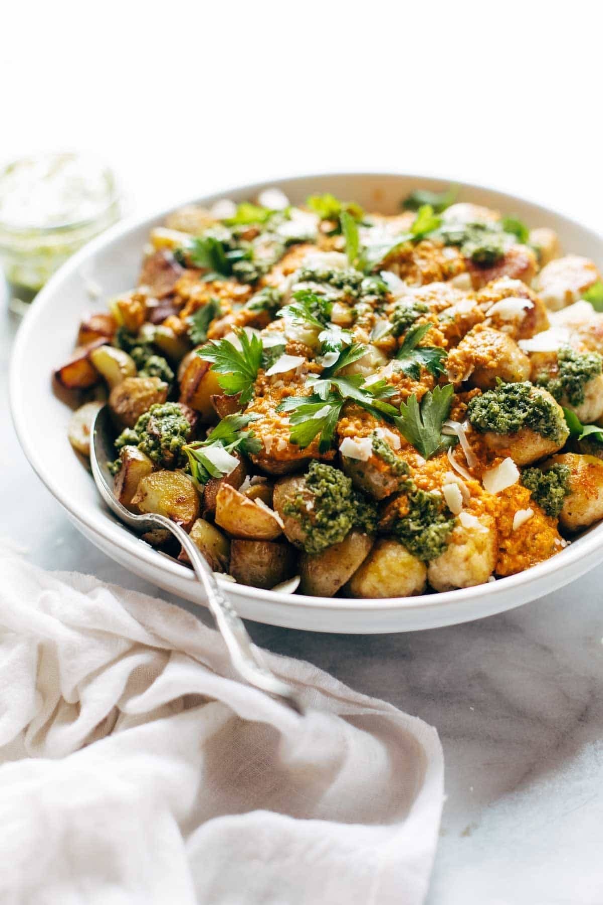 Meatballs and potatoes in a bowl with a napkin and a spoon.