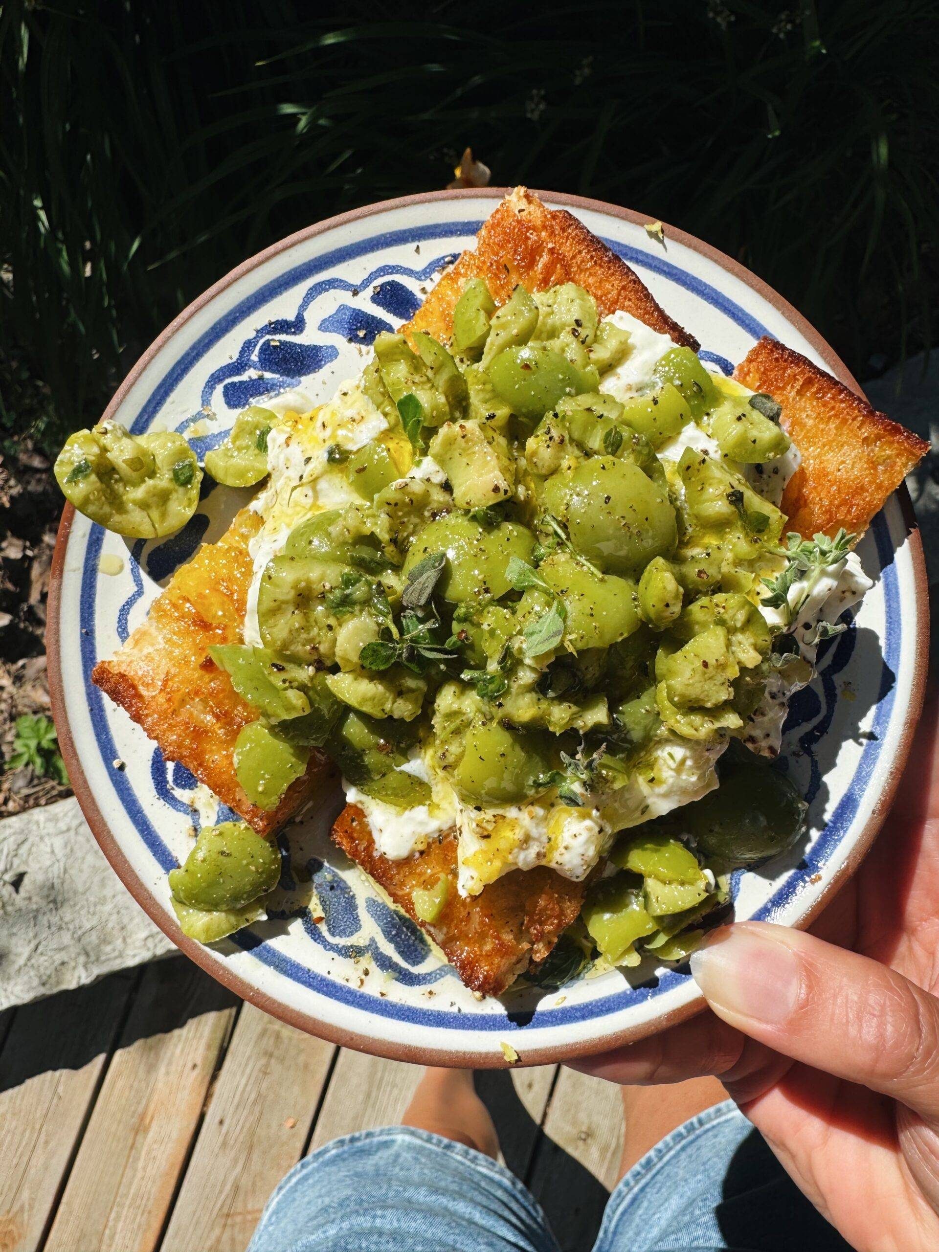 Smashed olives on bread with burrata.