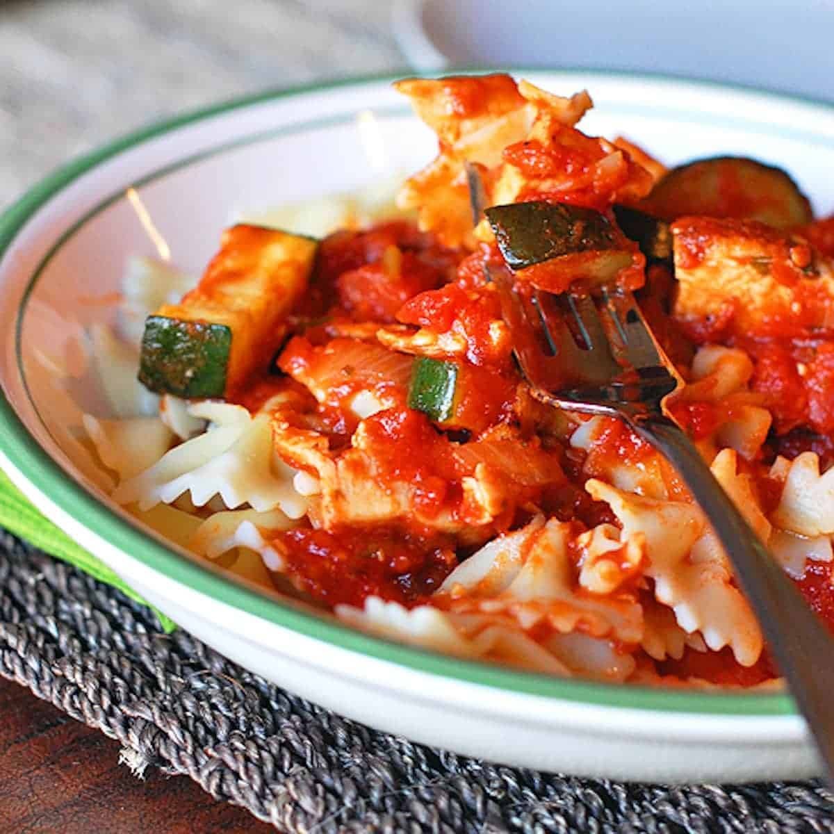 Chicken zucchini pasta in a bowl with a fork.